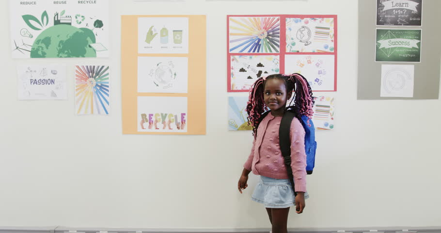 In school, young girl with backpack exploring colorful educational posters on wall. learning, curiosity, back to school, childhood, exploration, creativity
