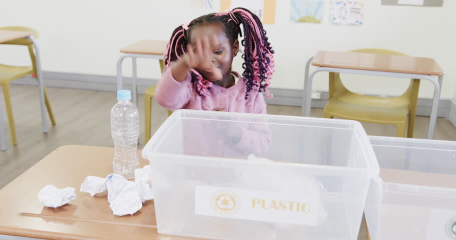 In school, girl sorting recyclables into bin, learning about environment conservation. Recycling, sustainability, eco-friendly, environmental education, green practices, waste management