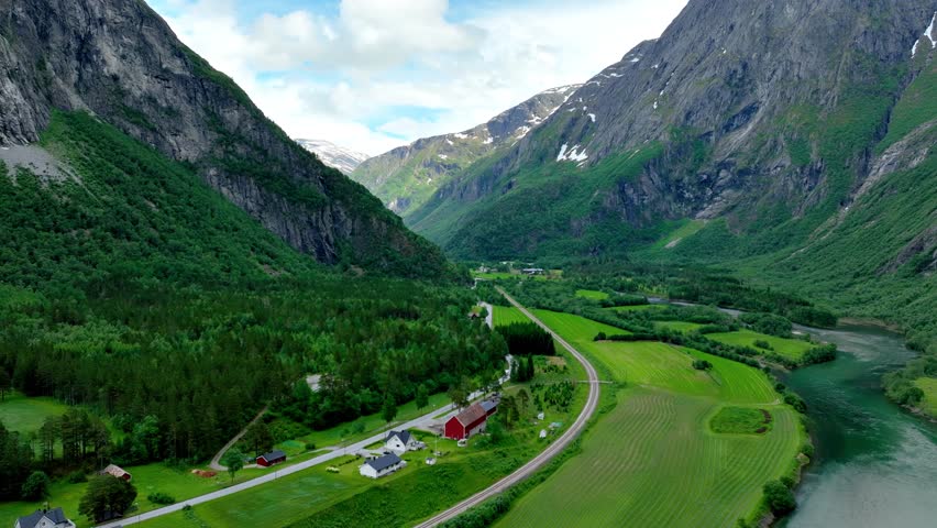 Aerial of the Rauma river winding through meadows and farmland in the Romsdalen Valley in Norway.