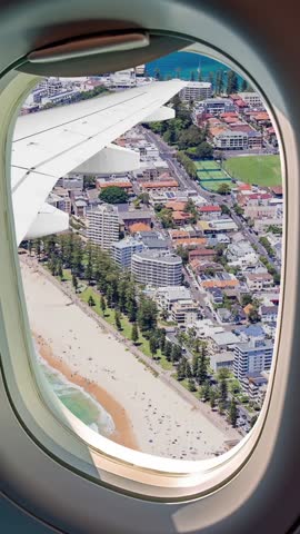Aerial view of the Northern Beaches tourist area in Manly, New South Wales, Australia. Panoramic view of Queenscliff, North Steyne, and South Steyne beach seen through an airplane window. 9x16 Format