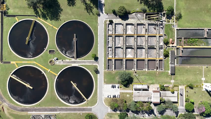 Aerial view of a industrial sanitation plant showing large-scale infrastructure, water tanks, pipelines, and ongoing wastewater treatment