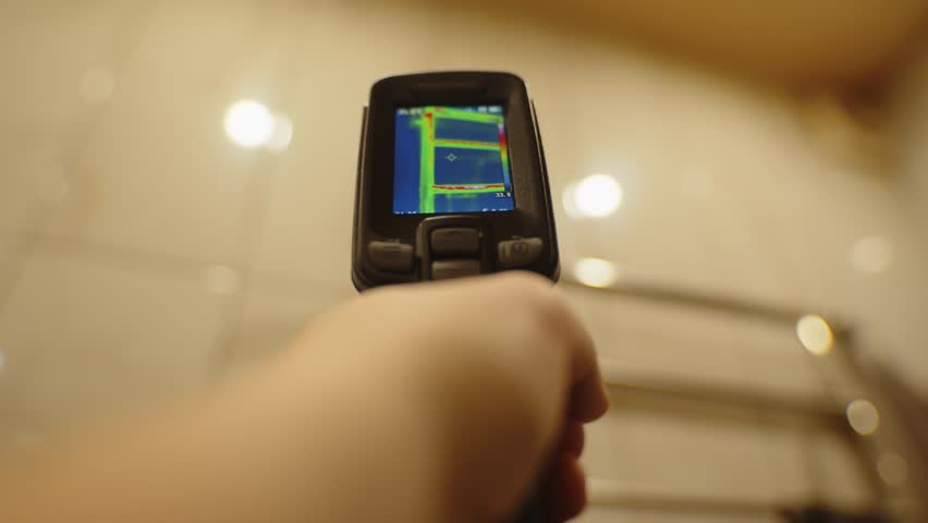 Thermal imaging camera detecting heat on bathroom wall