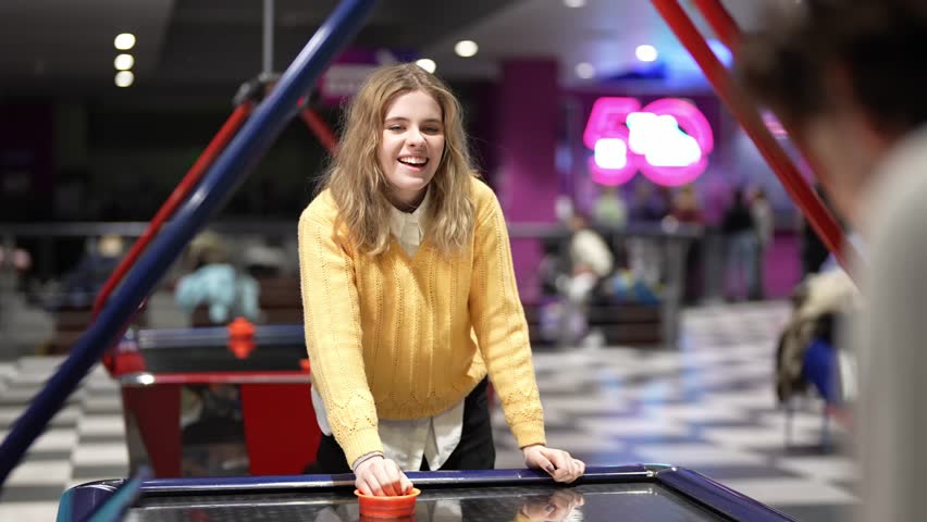 Enjoying a fun game of air hockey with friends in an arcade