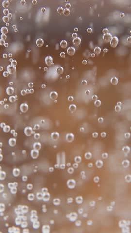Cascading sparkling water creates intensive bubble formation with thousands of tiny carbonation spheres dancing upward creating ultimate ASMR experience for viewers