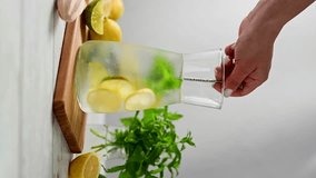 Lemonade with lemons, limes and fresh mint. Female hand mixing summer refreshing, homemade lemonade.  - Powered by Shutterstock - Get 15% off with code: PIKWIZARD15