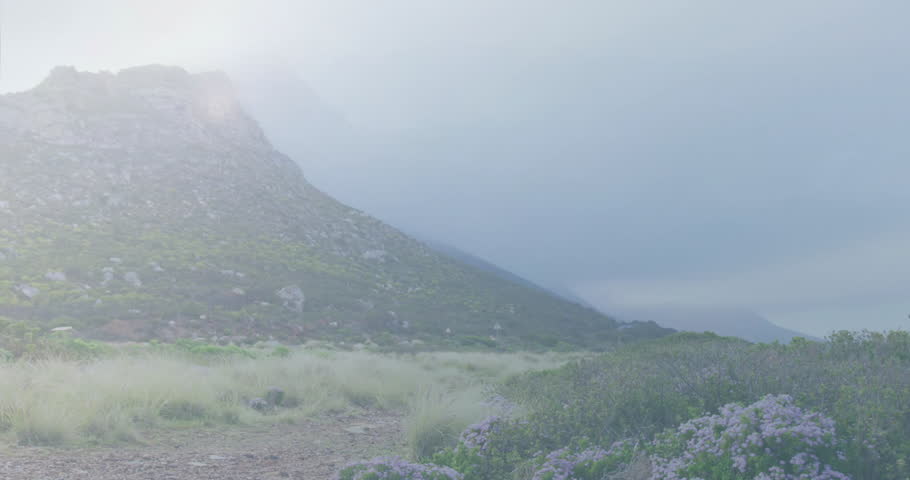 Sunlight warming hill initiating mist rising at base, forming cloud bank obscuring landscape. Mountains, landscape, atmospheric, scenic, tranquility, outdoor, nature