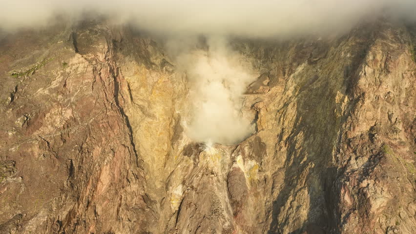 Daybreak illuminates gas billowing from the peak of Komba Island found just north of the Lesser Sunda Islands of Indonesia. This scenic and remote volcano has been extremely active for many years.