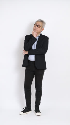 This is a portrait of an East Asian businessman with gray hair and glasses, dressed in a black suit, standing against a white background.