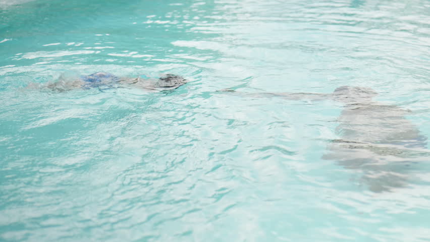 Asian boy dives toward his father in the swimming pool during a joyful holiday.4k