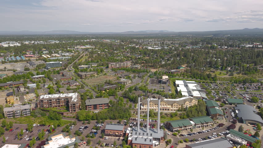 Drone flight over Deschutes River in Bend. People tubing and surfing on the river. Drone backwards 4k shot.