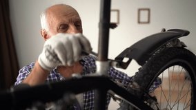 senior man fixing bicycle at home, adjusting rear fender on wheel. seasonal maintenance, transport repair, and cycling equipment service indoors. - Powered by Shutterstock - Get 15% off with code: PIKWIZARD15
