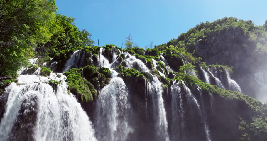 Lush Tiered Waterfalls Cascade Over Moss-covered Rocks In Dense Forest At Plitvice Lakes National Park, Croatia. ascending drone shot
