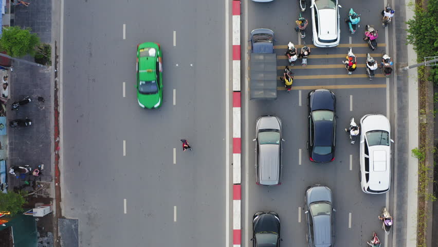 Hanoi , Vietnam - 04 29 2025: Top-down view of contrasting traffic flows in Hanoi, busy cars