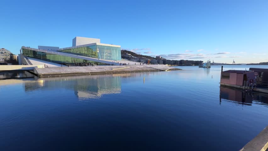 Oslo Opera House Norway Norge winter OsloFjord afternoon early sunset arctic sun clear skies tourist attraction people walking calm sea birds Oslo Library Munch sauna buildings pan left motion