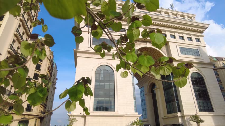 Soaring arch at Koh Pich Island in Phnom Penh, captured in vibrant daylight, showcasing intricate architectural grandeur against a clear blue sky. A stunning wide-angle architectural marvel.