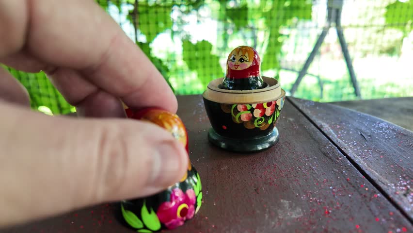 wooden matryoshka doll. Hand Holding a Wooden Matryoshka Doll – Traditional Russian Nesting Doll. Collection of traditional Russian nesting dolls. Beautiful handmade matryoshka dolls in a row.