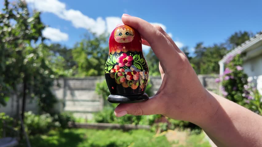 wooden matryoshka doll. Hand Holding a Wooden Matryoshka Doll – Traditional Russian Nesting Doll. Collection of traditional Russian nesting dolls. Beautiful handmade matryoshka dolls in a row.