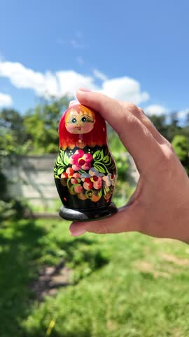wooden matryoshka doll. Hand Holding a Wooden Matryoshka Doll – Traditional Russian Nesting Doll. Collection of traditional Russian nesting dolls. Beautiful handmade matryoshka dolls in a row.