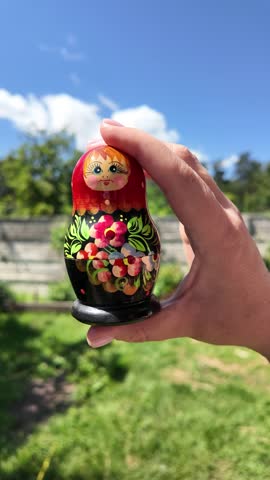 wooden matryoshka doll. Hand Holding a Wooden Matryoshka Doll – Traditional Russian Nesting Doll. Collection of traditional Russian nesting dolls. Beautiful handmade matryoshka dolls in a row.