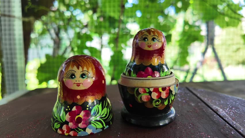 wooden matryoshka doll. Hand Holding a Wooden Matryoshka Doll – Traditional Russian Nesting Doll. Collection of traditional Russian nesting dolls. Beautiful handmade matryoshka dolls in a row.