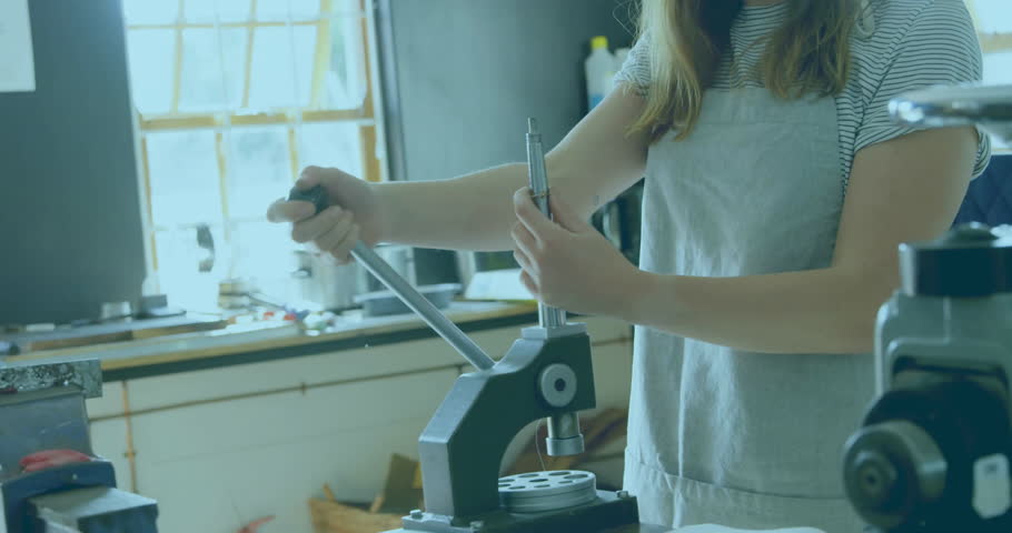 Craftsperson lifting rod under press, pulling lever then inspecting component for manufacturing. Artisan, craftsmanship, industrial, manual, workshop, precision, artisanal