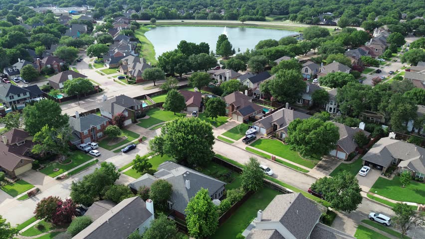 Waterfront upscale suburban neighborhood near Rheudasil Park in Flower Mound, suburbs Dallas Texas, lakeside two-story single-family houses, community pond with boardwalk, playground, lush trees. USA