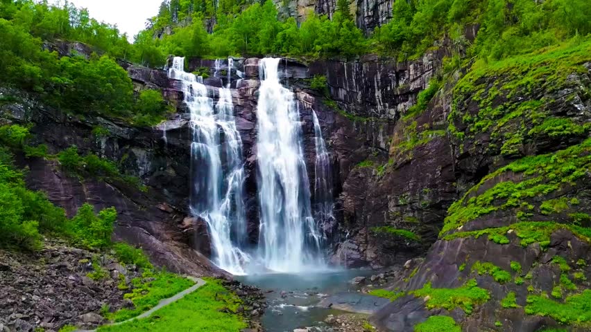 A beautiful aerial view of Skjervsfossen waterfall in Norway, showcasing the natural beauty of the surrounding Cliffs and cascading water, captured with drone footage.