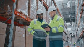 African American engineer with beard observing warehouse shelves while standing next to colleague. Focused male specialist holding tablet and checking digital records or coordinating stock levels. - Powered by Shutterstock - Get 15% off with code: PIKWIZARD15