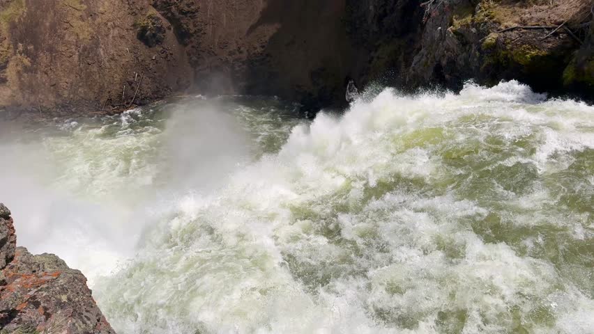 Close up view of the fast-flowing Yellowstone River dropping over the edge of the Upper Falls in Yellowstone National Park. 