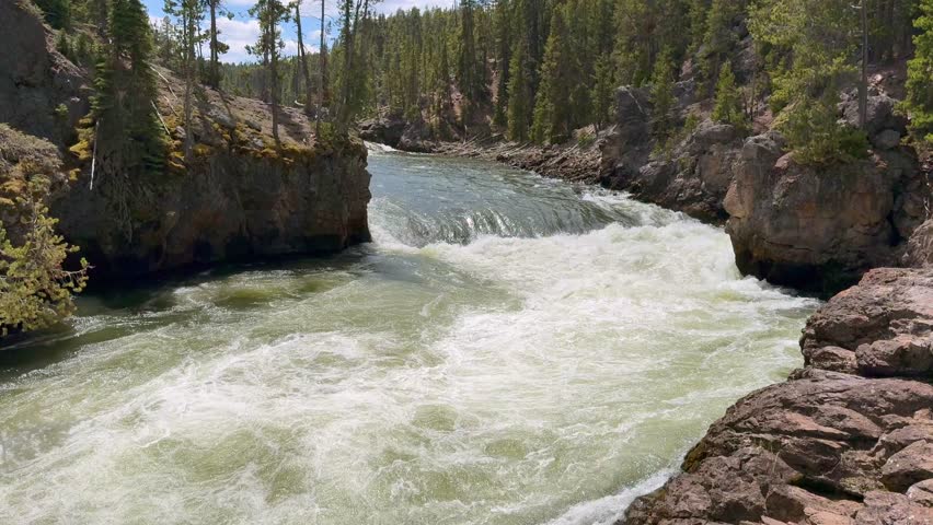 Scenic landscape view of water on the Yellowstone River before it reaches the Upper Falls in Yellowstone National Park.