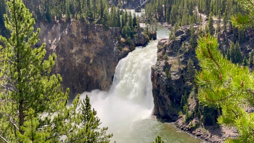 Scenic landscape view of the fast-flowing Yellowstone River dropping over the edge of the Upper Falls in Yellowstone National Park. 