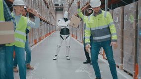 Humanoid robot holding package while walking through warehouse aisle surrounded by cheerful workers. Team raising arms and celebrating successful cooperation between automation and human staff. - Powered by Shutterstock - Get 15% off with code: PIKWIZARD15