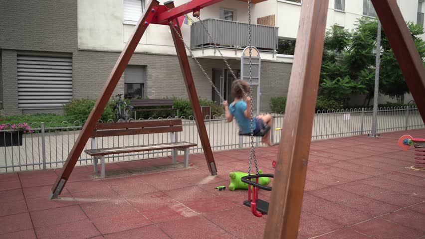 A child is riding a swing alone. Happy childhood during summer holidays