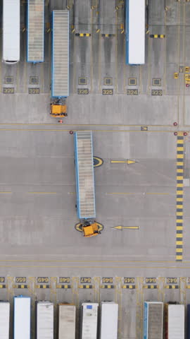 Vertical top down aerial view of trucks at distribution center in the United Kingdom. Logistics and delivery concept.
