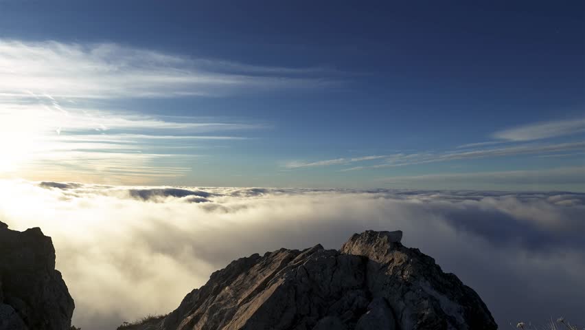 Revealing Religious Cross on Rocky Mountain Peak Above Clouds in Sunny Nature Like in Heaven