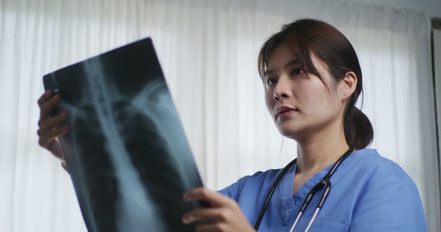 A medical professional analyzes a chest X-ray showing rib structure, highlighting specific areas with blue arrows for diagnosis or teaching.