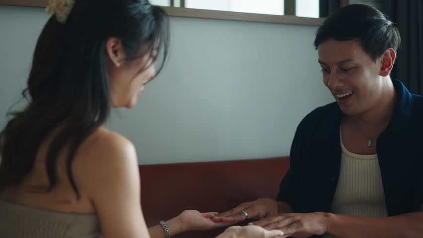 Happy couple enjoys playing a hand clapping game together on a couch - Powered by Shutterstock - Get 15% off with code: PIKWIZARD15