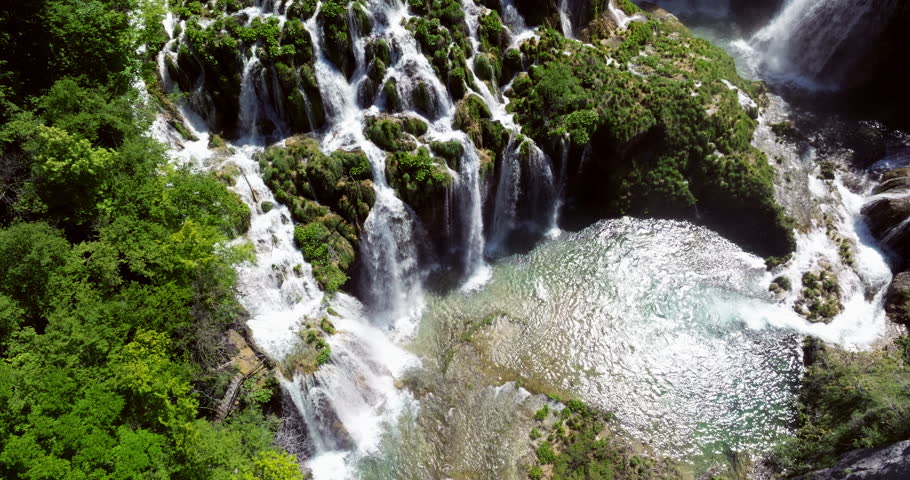 Waterfalls Cascade Over Lush Green Moss-covered Rock Formations At Plitvice Lakes National Park, Croatia. aerial shot