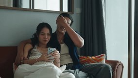 Pregnant couple gently reviewing smartphone, sitting closely on living room couch - Powered by Shutterstock - Get 15% off with code: PIKWIZARD15