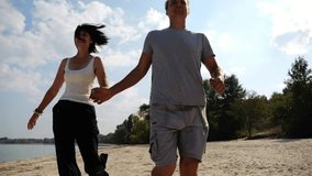 Romantic couple holding hands of each other and jogging at coastal. Happy pair running along seashore at sunny day. Lovers spending time together at resort. Concept of summer vacation or holiday - Powered by Shutterstock - Get 15% off with code: PIKWIZARD15