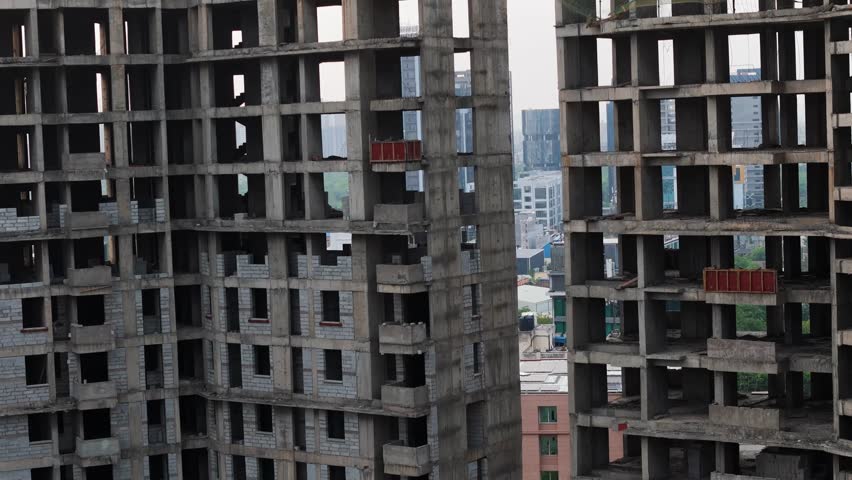 Aerial drone shot capturing early morning construction activity on tall buildings in Noida.