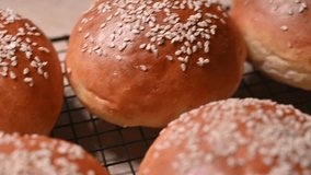 Freshly Baked Golden Burger Buns with Sesame Seeds Cooling on Wire Rack in Kitchen - Powered by Shutterstock - Get 15% off with code: PIKWIZARD15