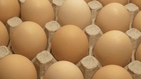 Fresh clean beige chicken eggs in cardboard tray rotates, top view - Powered by Shutterstock - Get 15% off with code: PIKWIZARD15
