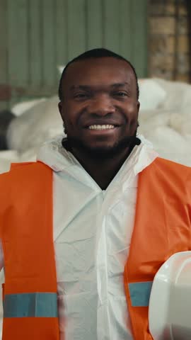 A dedicated worker beams with pride in an eco-friendly recycling facility, highlighting the significance of teamwork and sustainability during a busy workday