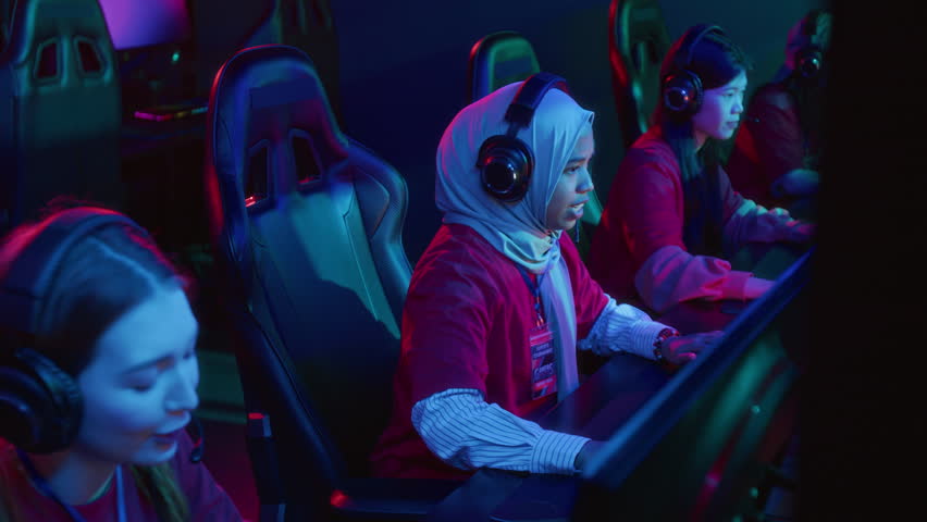 Medium shot of anxious multiethnic female gamers playing video game in online championship, cheering desperately, loosing match with adversary team. Ideal for online gaming tournament commercials 