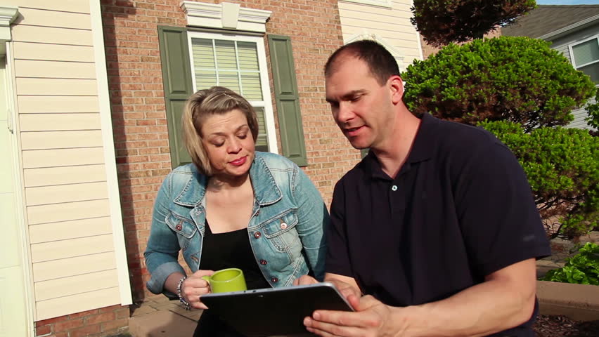 A couple uses a tablet PC outside.