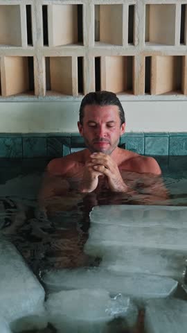 Handsome Man Diving into Cold Water of Swimming Pool with Ice Cubes for Good Body Health. Healthy Person in Bathtub Full of Chilly Aqua for Youth Therapy. Remedy of Depression and Anxiety Condition