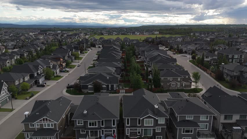 Aerial view of suburban neighbourhood of Aspen Estates in Calgary on a stormy summer evening. 