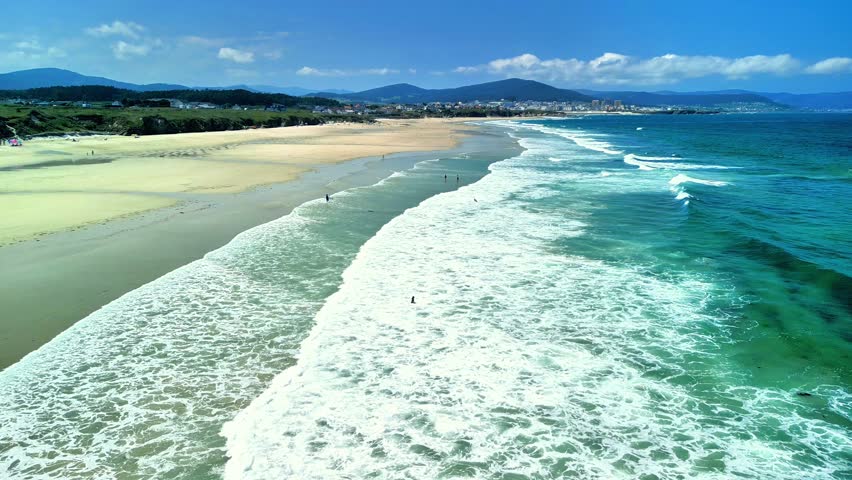 Experience the Beautiful Aerial View of a Serene Beach with Gentle Waves and Blue Sea
