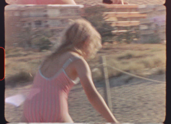 Vintage vibes emanate from this zooming shot of a hotel complex, complete with a prominent pine tree, likely located in Spain during the 1970s